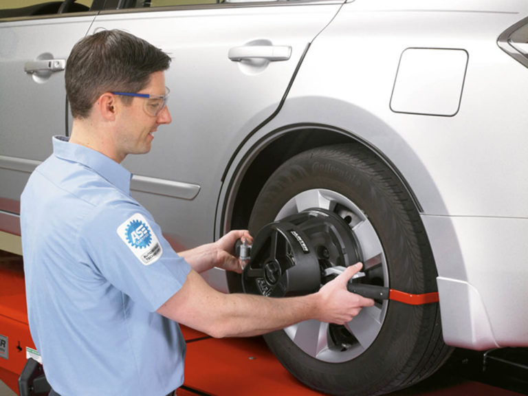 Wheel fitter using hunter wheel alignment tools on silver car